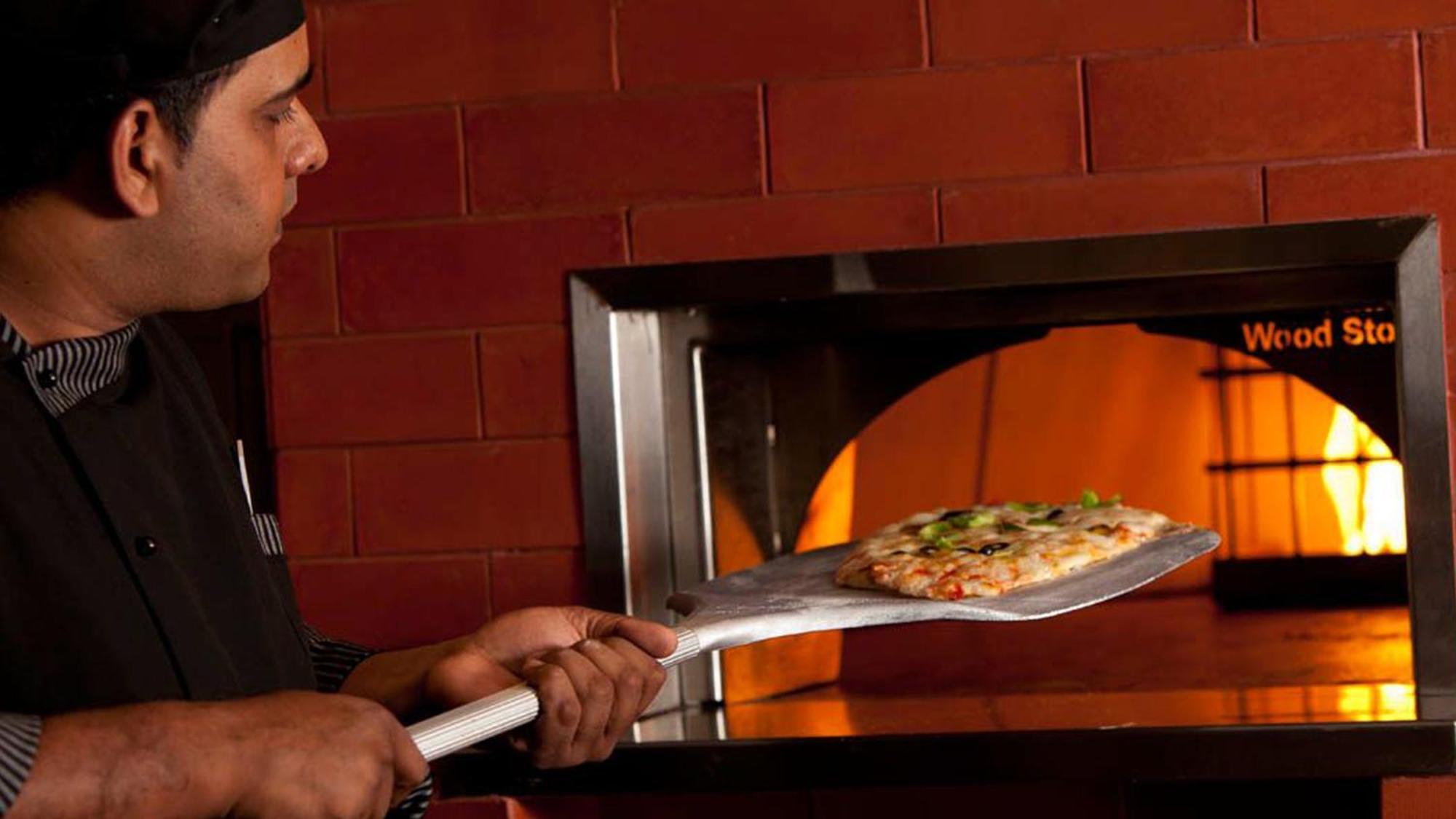 Holiday Inn Cochin, An Ihg Hotel Kochi Exterior photo Pizza being removed from a wood-fired oven